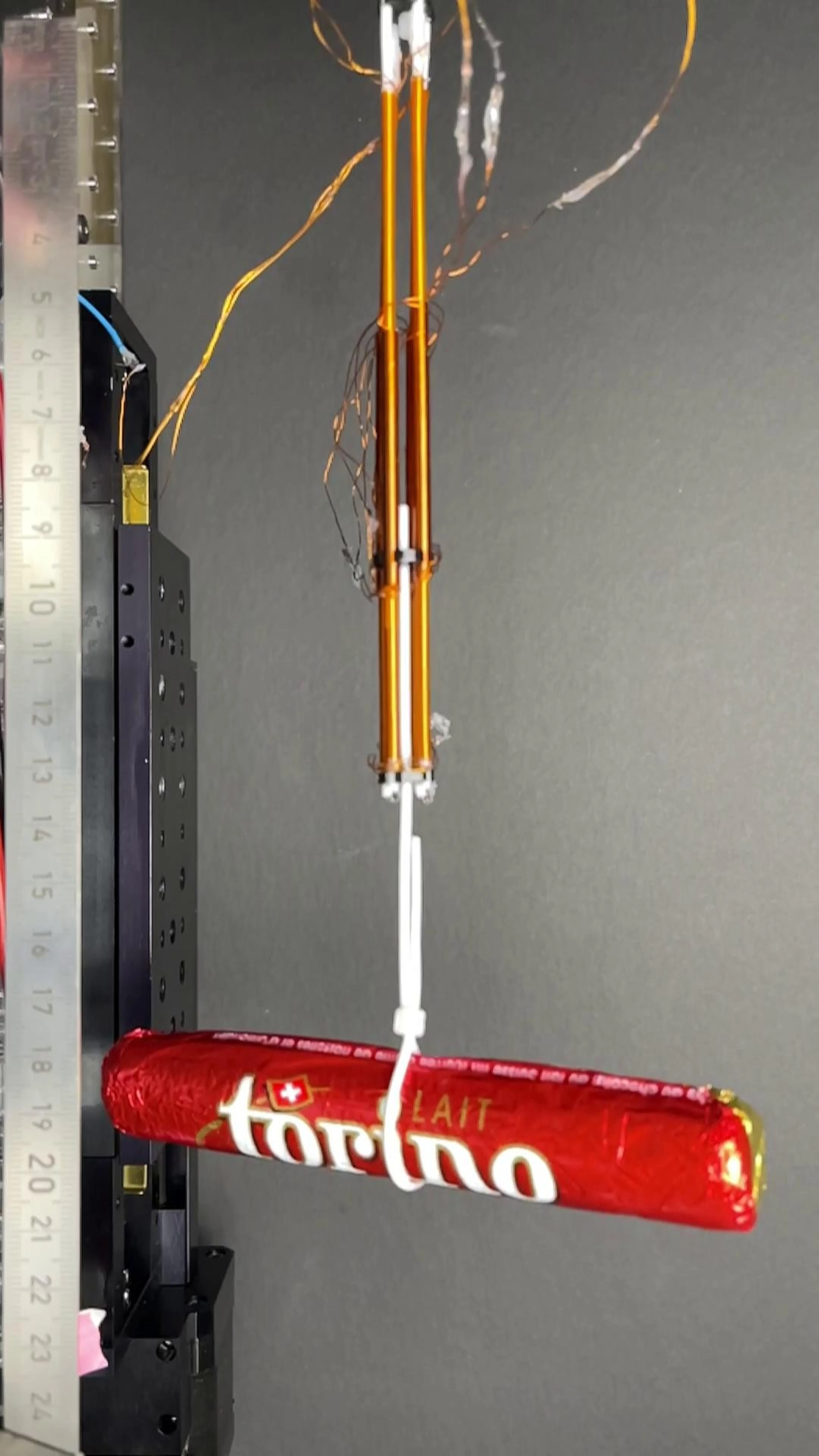 Cuatro FiberMotor agrupados levantan una barra de chocolate